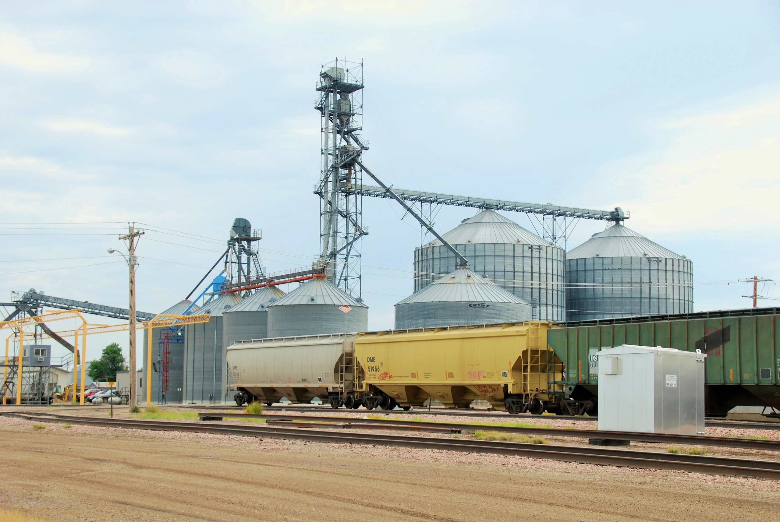 Image shows a grain elevator and grain hopper rail cars to illustration rail shipping.
