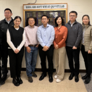 Several wheat buyers from China, Dr. Byung Kee Baik, USW staff stand in front of the directory at the ARS Soft Wheat Quality Lab in Wooster, Ohio.
