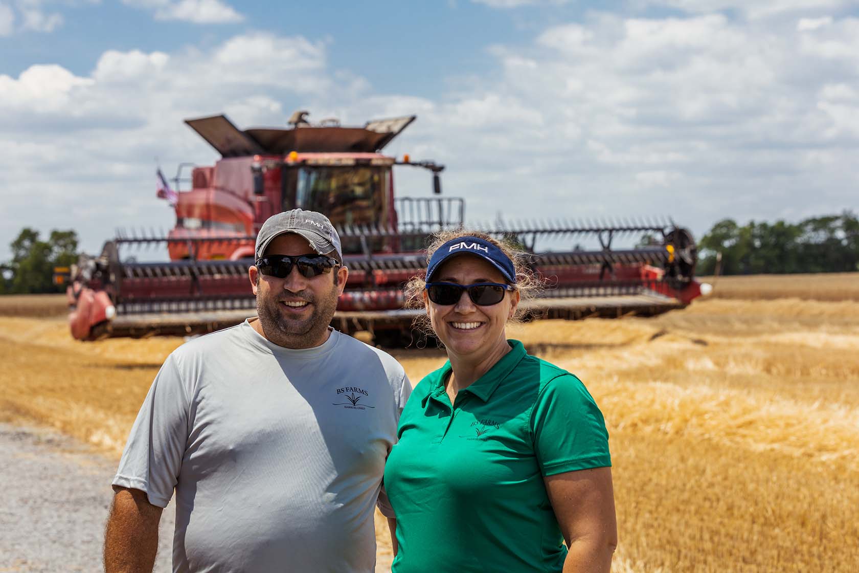 Ben and Stephanie Bowsher of Ohio standing together in front of a combine in their soft red winter wheat field.