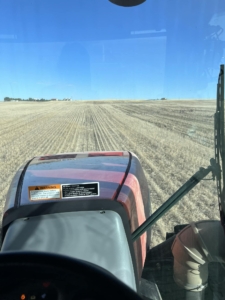Image from inside a tractor of a dry Montana field in which Denise Conover is seeding winter wheat