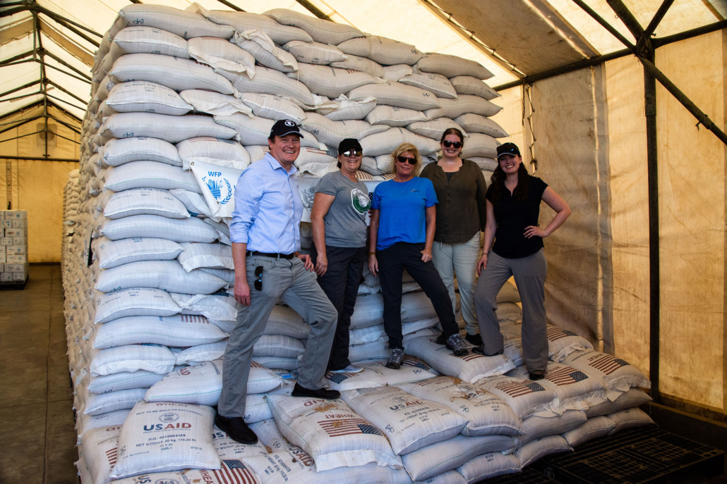 People standing near bags of U.S. wheat donated by International food assistance in Kenya.