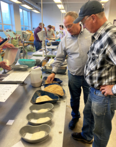 In a flour milling lab at Kansas State University, USW's Mark Fowler and Kansas Farmer Martin Kerschen discuss the variety of flour products resulting from the milling process.